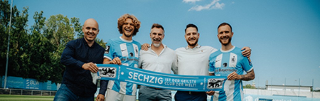 Verschiedene Vertreter des TSV 1860 halten gemeinsam einen Schal mit dem Schriftzug "Sechzig ist der geilste Club der Welt"