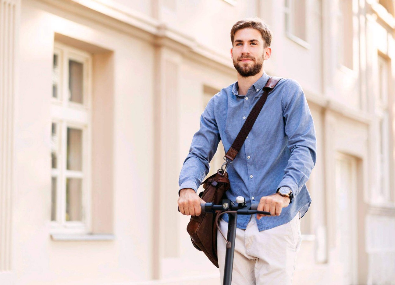 Junger Mann fährt durch die Straßen mit einem E-Scooter.