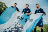 Drei Spieler des TSV 1860 breiten eine Fahne des Vereins aus: Zwarts, Sulejmani und Rieder