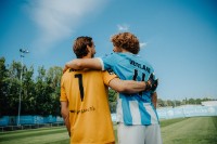 Spieler des TSV 1860 Marco Hiller und Jesper Verlaat stehen Arm in Arm auf dem Fußballplatz