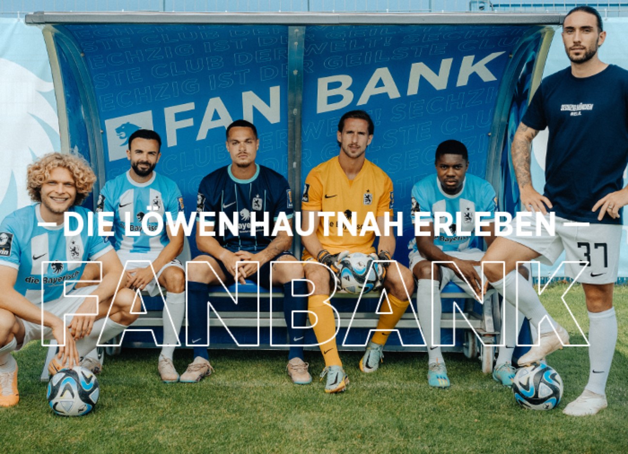 Mehrere Spieler des TSV 1860 auf einer Bank am Spielfeldrand mit Schriftzug "Fanbank"
