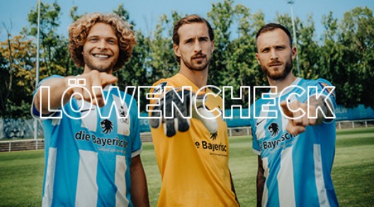 Im Hintergrund: Drei Spieler des TSV 1860 schauen und zeigen in die Kamera, im Vordergrund Schriftzug "Löwencheck"