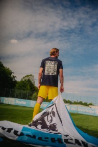 Spieler des TSV 1860 Marco Hiller steht mit einer Fahne auf dem Spielfeld