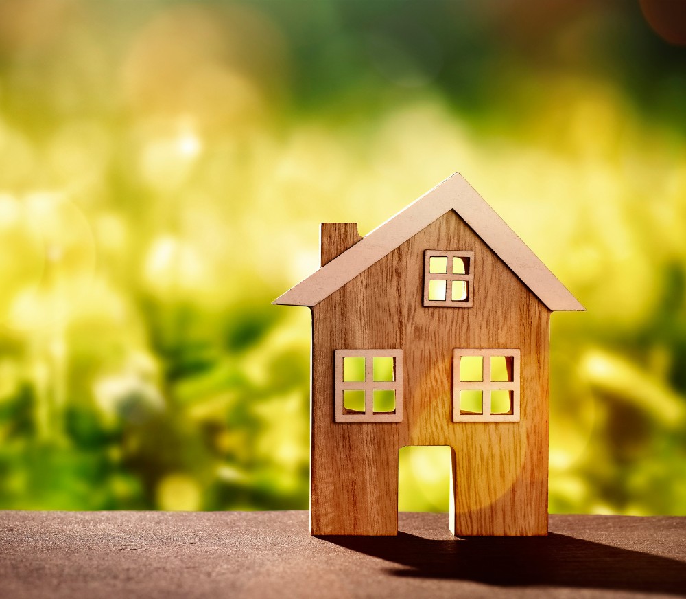 Ein dekoratives kleines Holzhaus stehend auf einem Holzbalken in der Natur