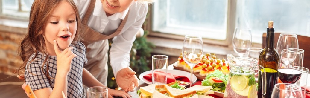 Eine ältere Dame und ein junges Mädchen stehen gemeinsam an einem Weihnachtsbuffet.