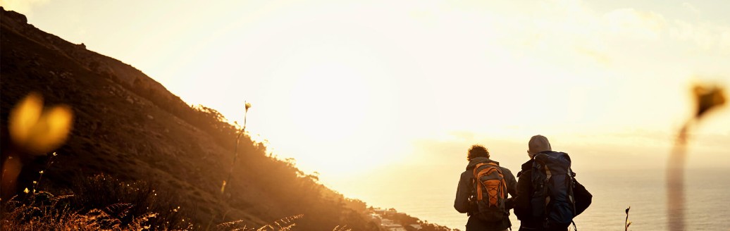 Two hikers on the coast during sunset