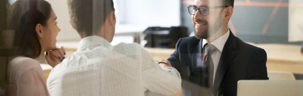 Ein Business-Mann führt ein Beratungsgespräch mit zwei Kunden. 