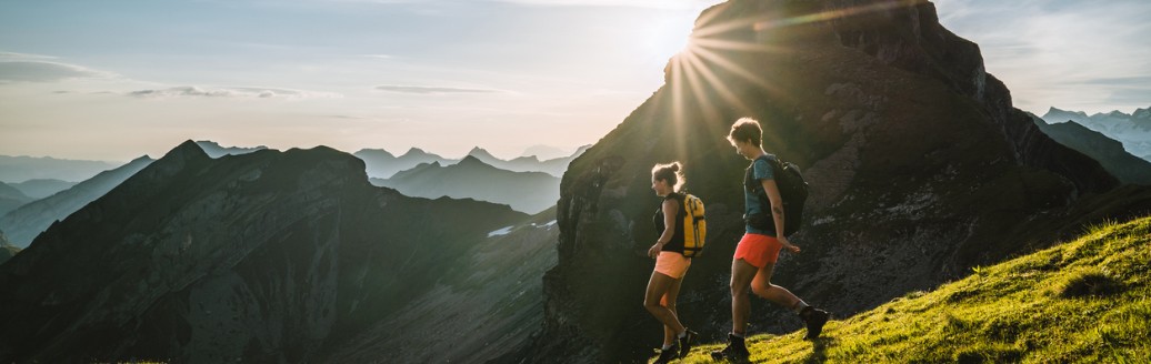 Zwei Frauen wandern an einem sonnigen Tag durch die Berge.
