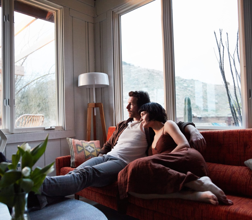 Ein Mann und eine Frau kuscheln sich auf dem Sofa aneinander.