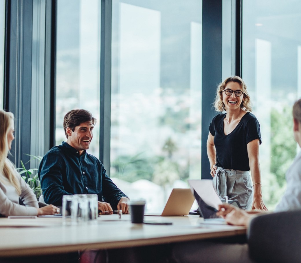 Ein vierköpfiges Team diskutiert in einem hellem Büro mit großen Fenstern