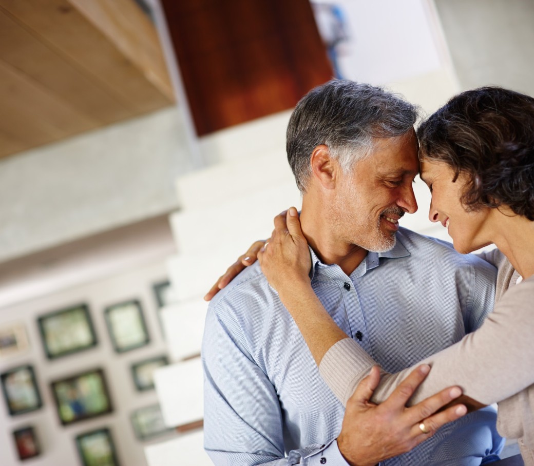 Ein Mann und eine Frau schauen sich vertraut an und berühren sich an Armen und Stirn