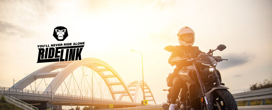 Motorradfahrerin fährt in der Abendsonne, links im Bild das Logo von RideLink