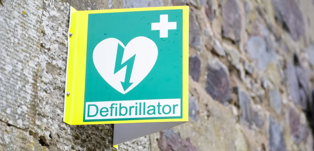 Das Bild zeigt die Ausschilderung einer Station mit einem Defibrillator. 