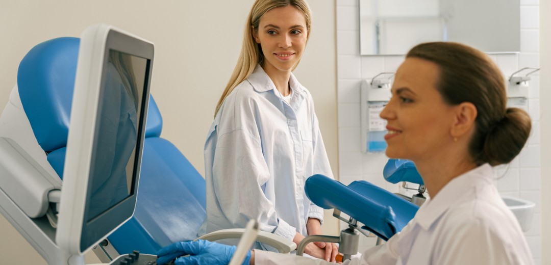 Patientin beim Gynäkologen, Ärztin bereitet eine Untersuchung im Behandlungsraum vor.