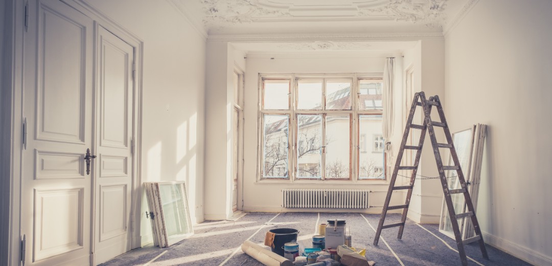 Das Bild zeigt einen leerstehenden, weißen Altbau-Raum, der gerade renoviert wird. 