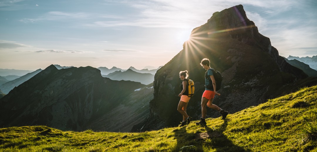 Zwei Frauen wandern an einem sonnigen Tag durch die Berge.