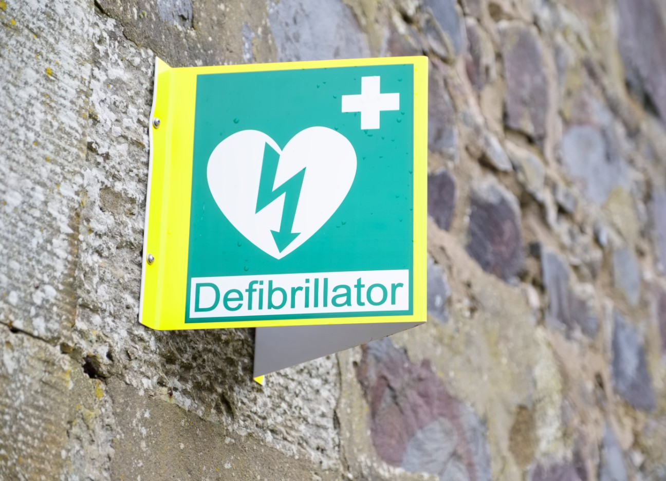 Das Bild zeigt die Ausschilderung einer Station mit einem Defibrillator. 