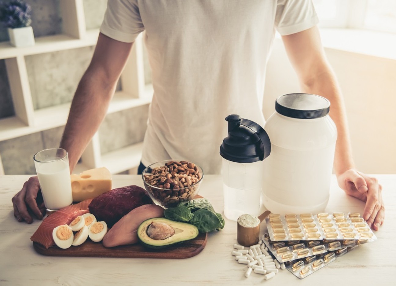 Bühnenbild Ratgeber High-Protein Trend Ein Mann, dessen Oberkörper lediglich zu sehen ist, steht hinter einem proteinreichen Frühstück. Das Frühstück steht im Fokus der Aufnahme.