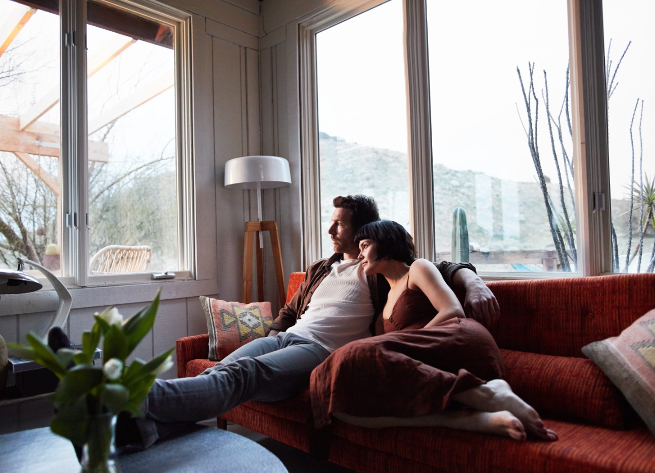 Ein Mann und eine Frau kuscheln sich auf dem Sofa aneinander.