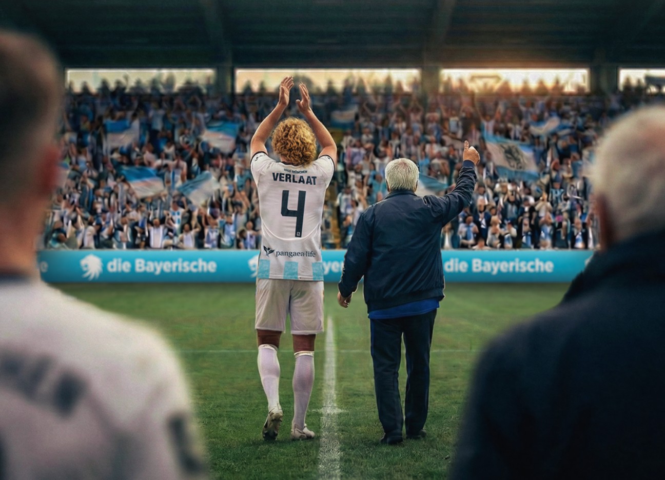 Spieler des TSV 1860 laufen ins Fußballstadion ein - begleitet von Senioren