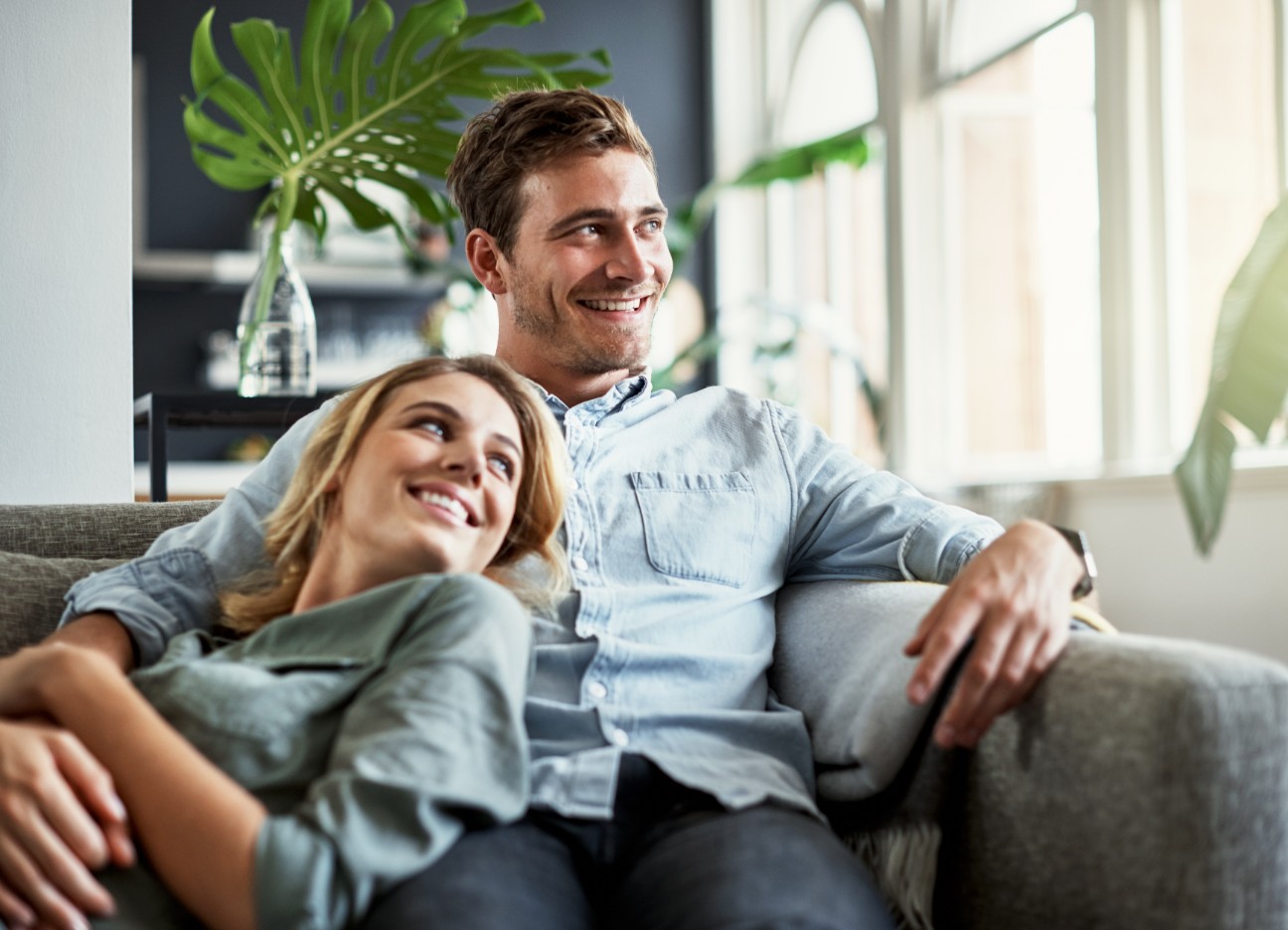 Mann und Frau sitzen gemütlich gemeinsam auf der Couch Mann und Frau sitzen gemütlich gemeinsam auf der Couch