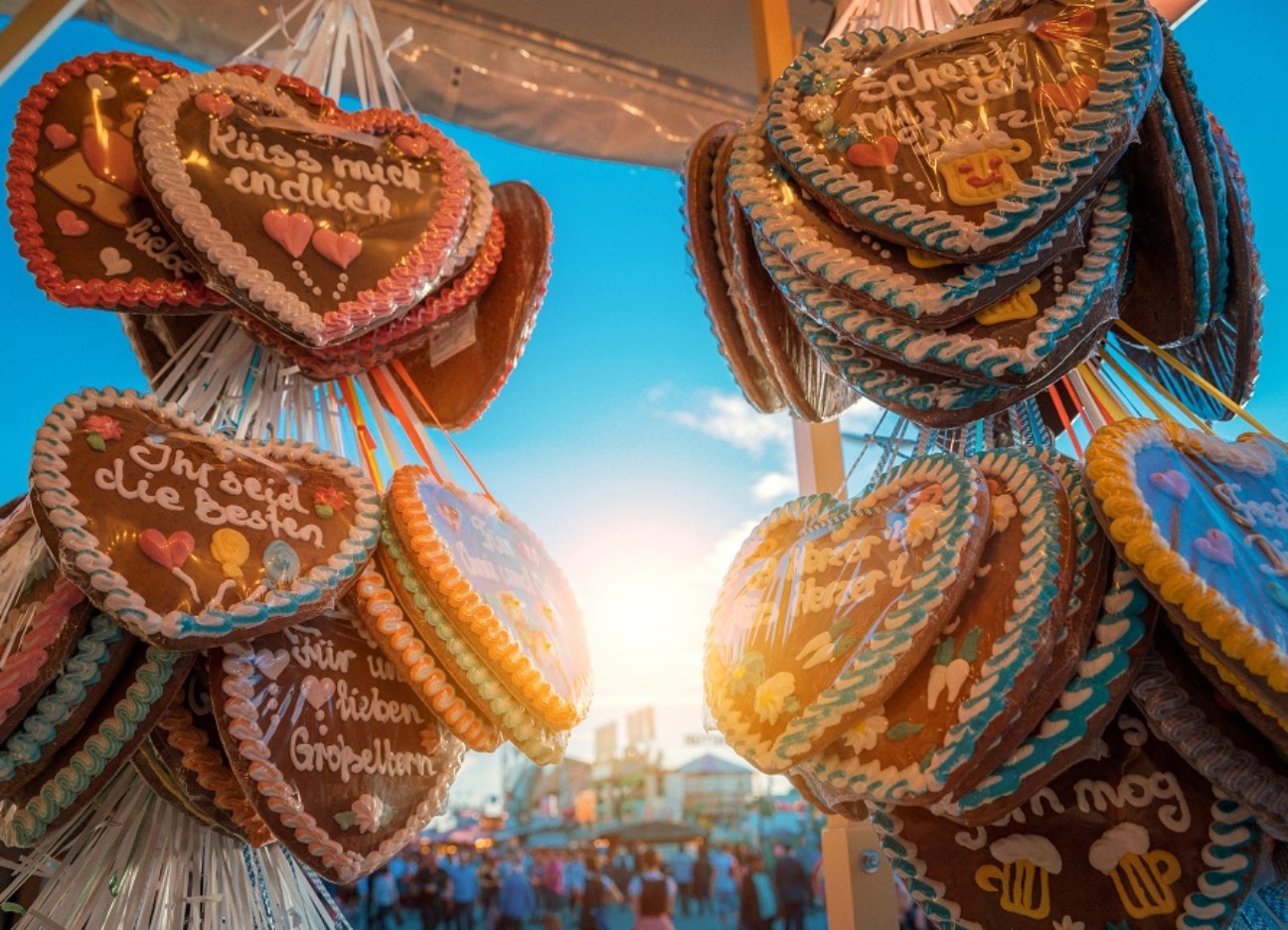 Bühnenbild Ratgeber Gut versichert auf die Wiesn – alles, was man wissen muss Fotografie von mehreren Wiesn-Lebkuchenherzen an einem Stand hängend.