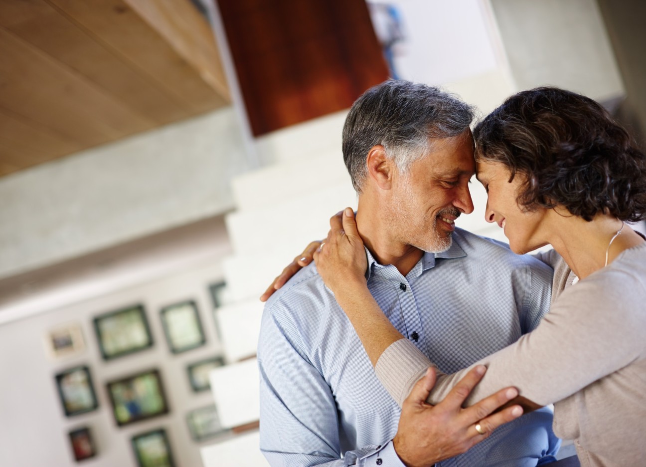 Ein Mann und eine Frau schauen sich vertraut an und berühren sich an Armen und Stirn