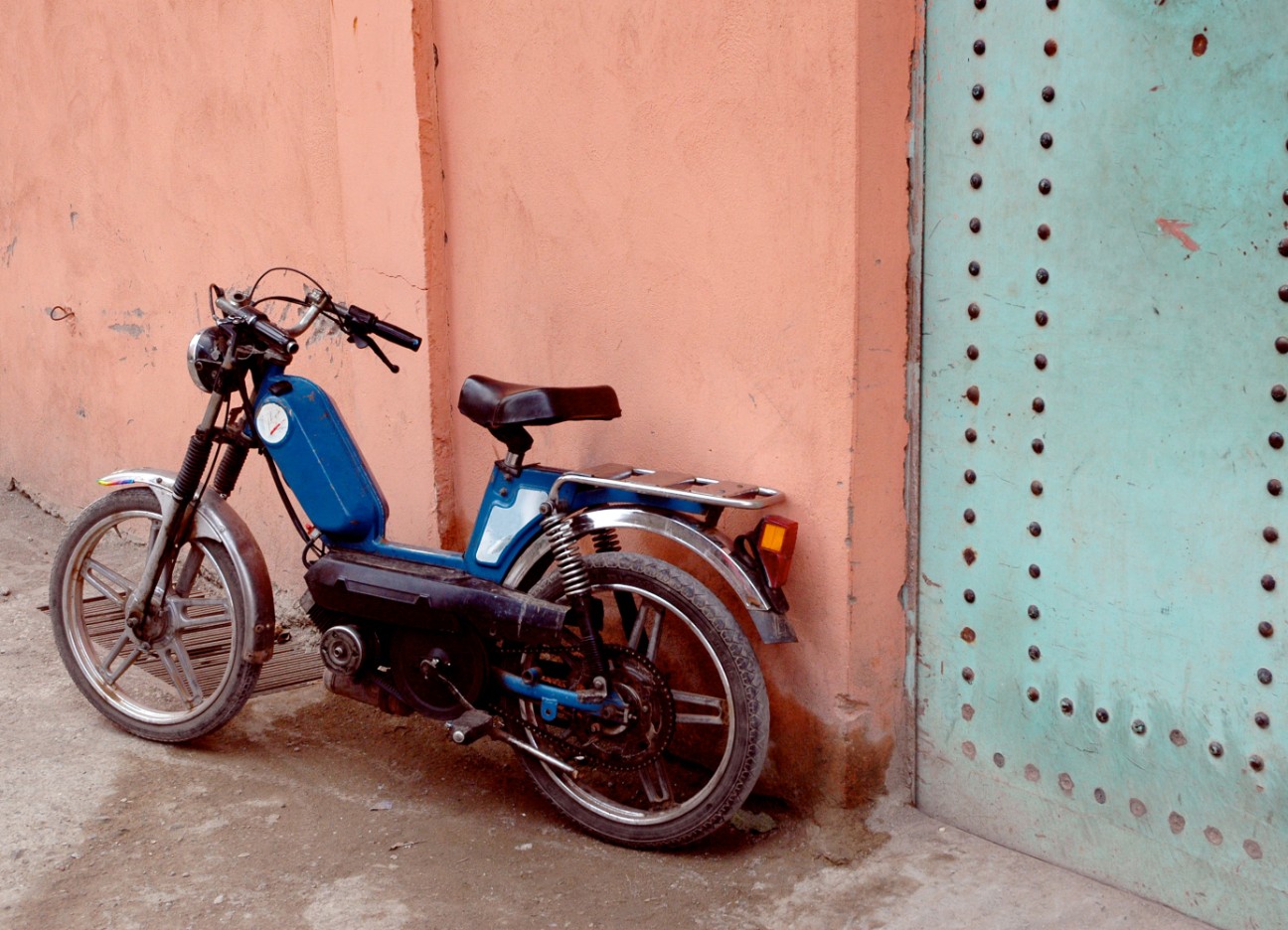 Bühnenbild Ratgeber Sommertrend Moped Das Bild zeigt ein älteres Moped, welches an einer Altbau-Hauswand gelehnt ist.