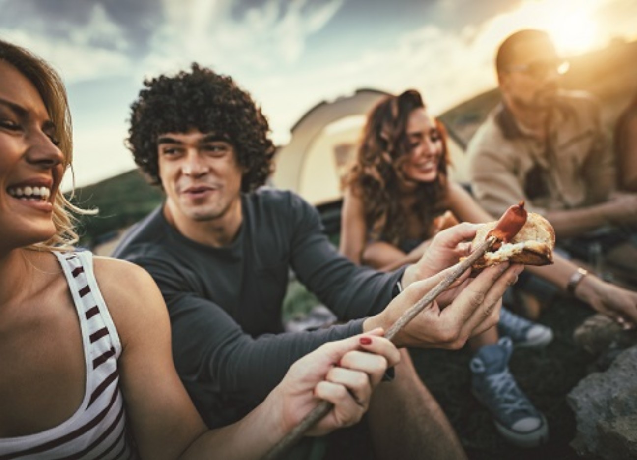 Bühnenbild Ratgeber Grillirrtümer Mehrere Freunde sitzen zusammen und grillen