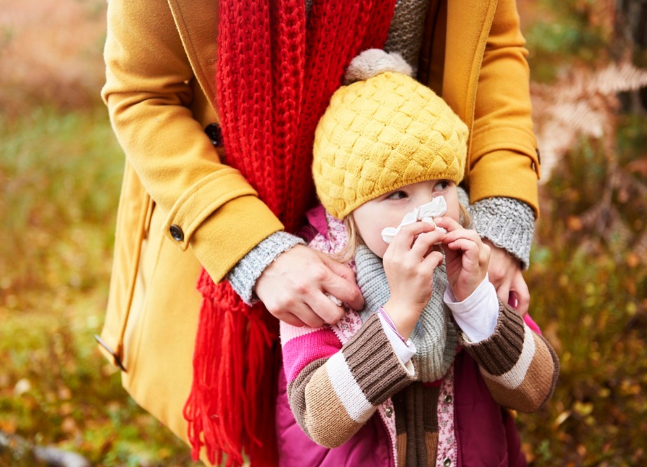 Bühnenbild Ratgeber Diese Medikamente gehören in die Hausapotheke! Ein kleines Mädchen im Herbstoutfit putzt sich die Nase.