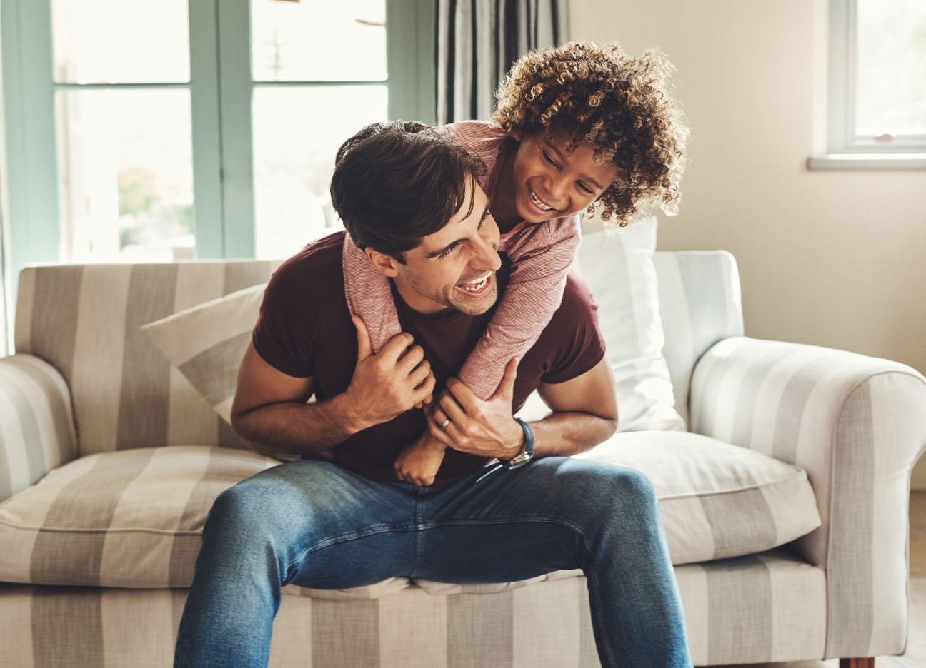 Vater und Kind tollen zuhause auf dem Sofa Vater und Kind tollen zuhause auf dem Sofa