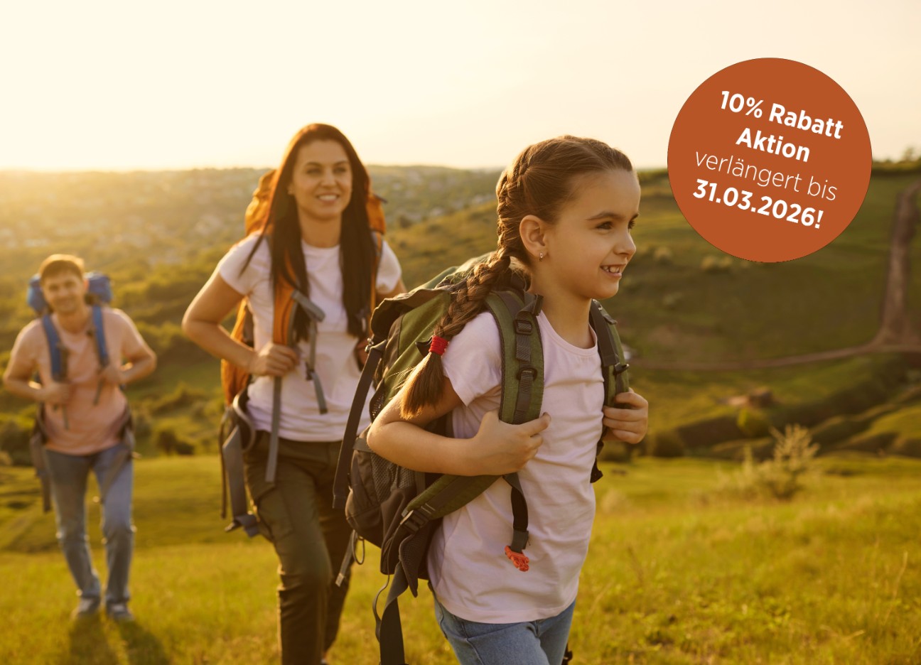 Junges Paar mit Tochter beim Wandern in leicht hügeliger Umgebung, Titelbild mit Hinweis auf 10% Rabatt