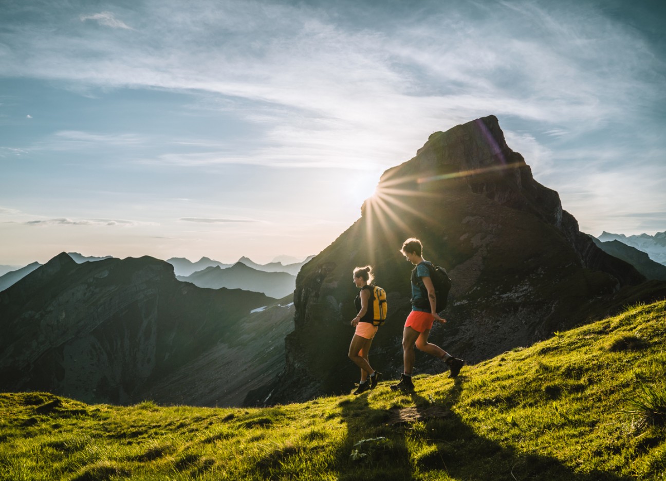 Zwei Frauen wandern an einem sonnigen Tag durch die Berge.
