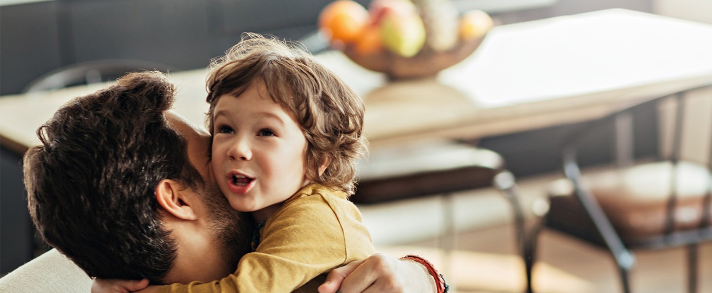 Ein junges Paar steht mit Müslischalen in der Hand steht lachend in der Küche