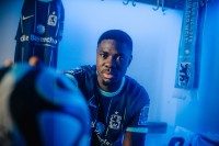 Spieler des TSV 1860 Leroy Kwadwo sitzt in der Kabine in hält einen Fußball in die Kamera