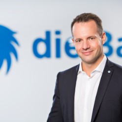 Portrait von Max Buddecke vor die Bayerische Logo