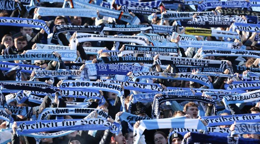 Fans des TSv 1860 halten ihre Fan-Schals in die Höhe