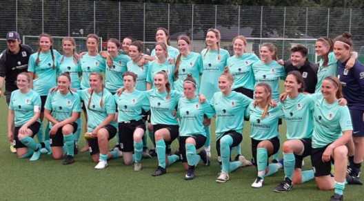 Fußballmannschaft in hellblauen Trikots posiert auf einem Spielfeld. Fußballmannschaft in hellblauen Trikots posiert auf einem Spielfeld.