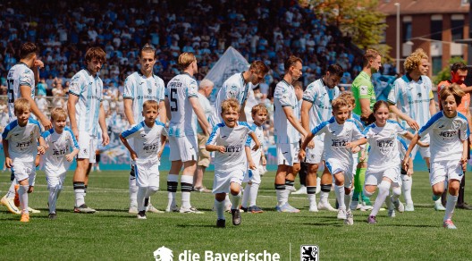 Mehrere Fußballspieler des TSV 1860 und Einlaufkinder