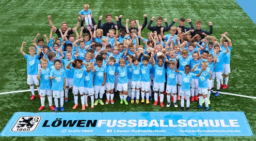 Gruppe von Kindern in blauen Trikots der Löwen-Fußballschule auf einem Fußballfeld. Gruppe von Kindern in blauen Trikots der Löwen-Fußballschule auf einem Fußballfeld.