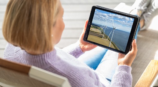 Magdalena Neuner sitzt im Sessel und schaut sich auf einem Tablet die Pangaea Life Investmentreise an Magdalena Neuner sitzt im Sessel und schaut sich auf einem Tablet die Pangaea Life Investmentreise an