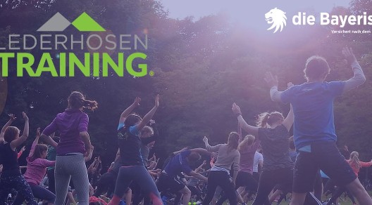 Gruppe von Menschen beim Outdoor-Training, mit dem Logo "Lederhosen Training" und "die Bayerische" im Hintergrund. Gruppe von Menschen beim Outdoor-Training, mit dem Logo "Lederhosen Training" und "die Bayerische" im Hintergrund.