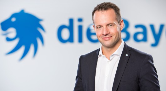 Portrait von Max Buddecke vor die Bayerische Logo