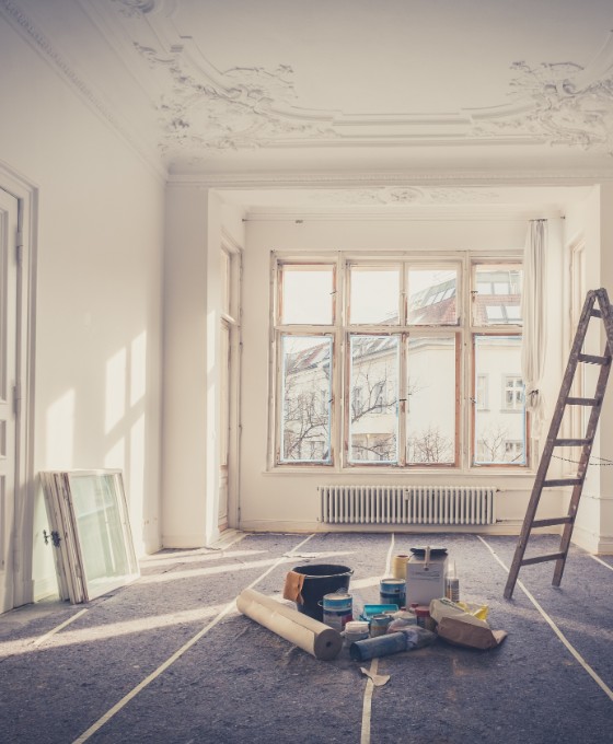 Das Bild zeigt einen leerstehenden, weißen Altbau-Raum, der gerade renoviert wird. 