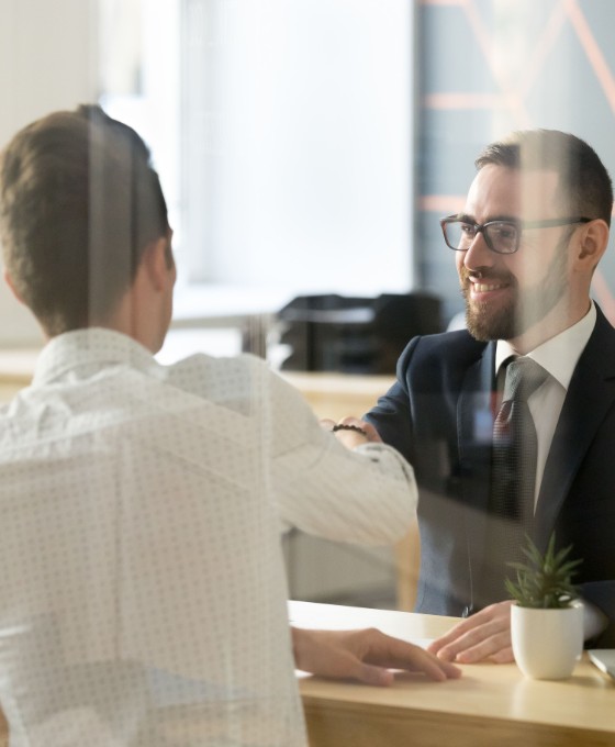 Ein Business-Mann führt ein Beratungsgespräch mit zwei Kunden. 