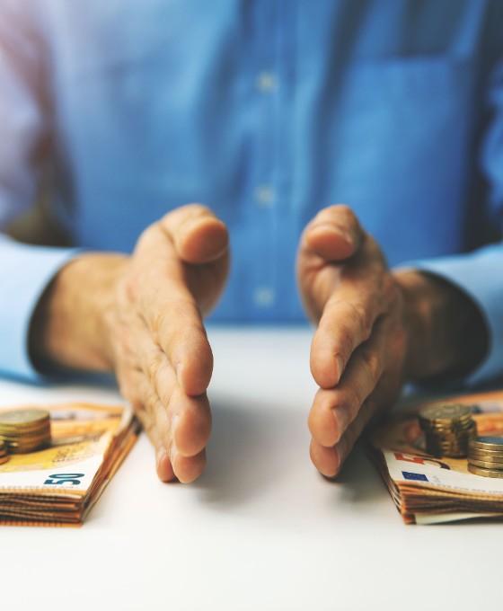 Ein Mann teilt Bargeld in zwei Stapel auf. 