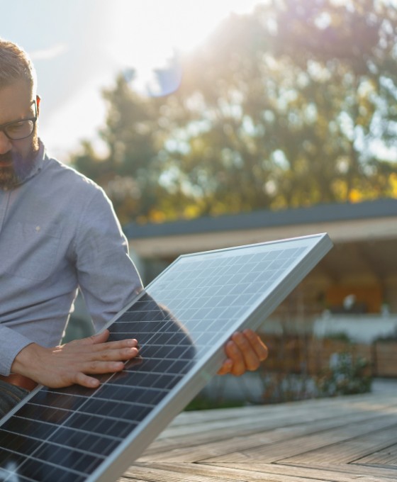 Vater zeigt seiner kleinen Tochter ein Solarpaneel für eine Photovoltaik-Anlage