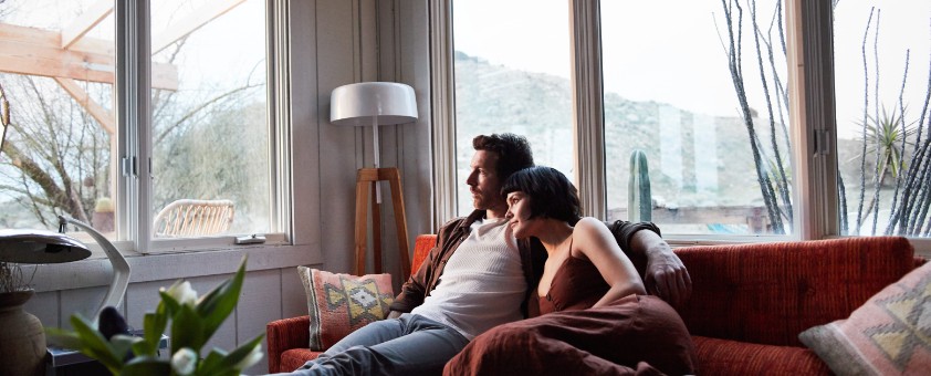 Ein Mann und eine Frau kuscheln sich auf dem Sofa aneinander.