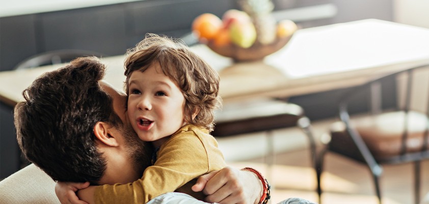 Ein junges Paar steht mit Müslischalen in der Hand steht lachend in der Küche