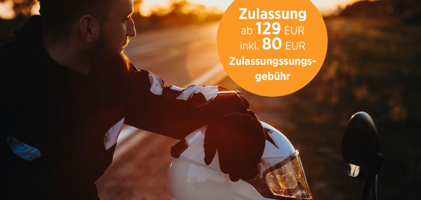 Motorradfahrer macht während einer Fahrt bei Sonnenuntergang eine Pause. Der Helm liegt auf dem Motorrad.